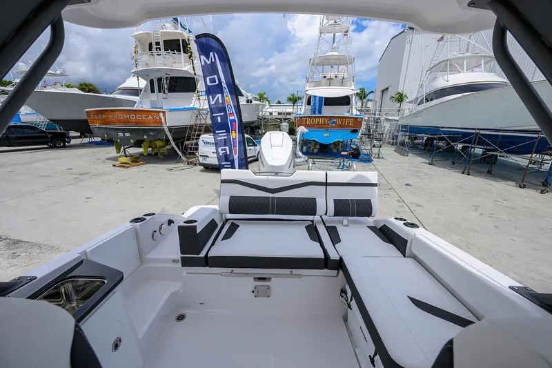 Slide: The Image of 2026 Monterey Elite 27 OB boat interior at marina with yachts in background. - 11