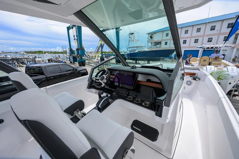 Slide: The Image of 2026 Monterey Elite 27 OB boat interior with modern dashboard and seating at marina. - 16