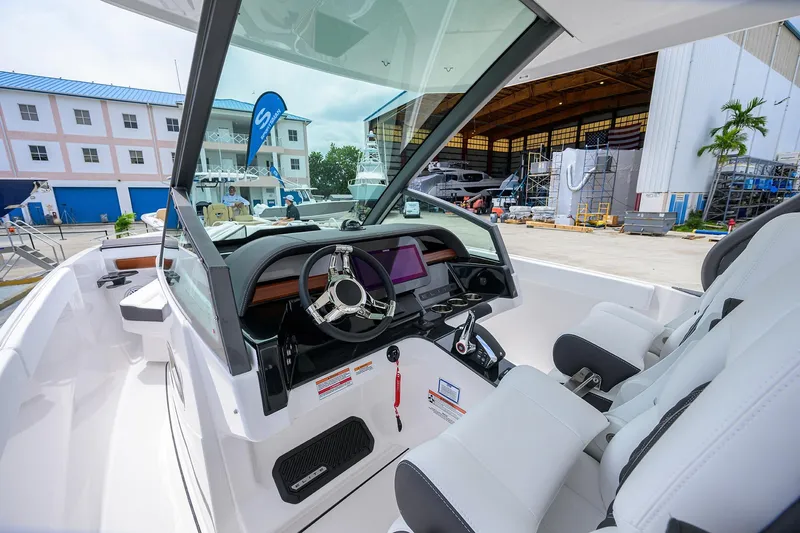 Slide: The Image of Interior view of 2026 Monterey Elite 27 OB boat with modern dashboard and seating. - 17