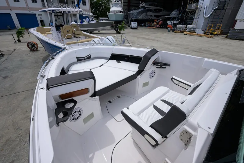 Slide: The Image of 2026 Monterey Elite 27 OB boat interior with white seating and cup holders in a marina setting. - 4