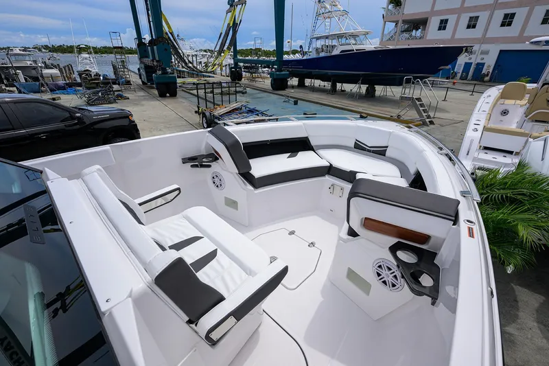 Slide: The Image of 2026 Monterey Elite 27 OB boat interior with luxurious seating and modern design at a marina. - 5
