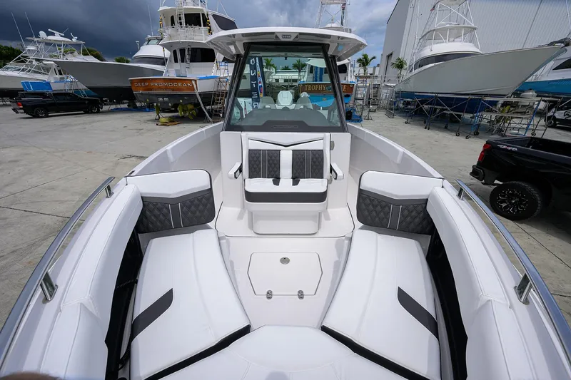 Slide: The Image of 2026 Monterey Elite 27 OB boat interior with luxurious seating at a marina. - 6