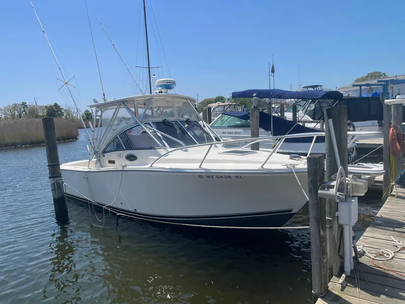 Slide: The Image of 2003 Albemarle 260 boat docked in marina under clear blue sky. - 11