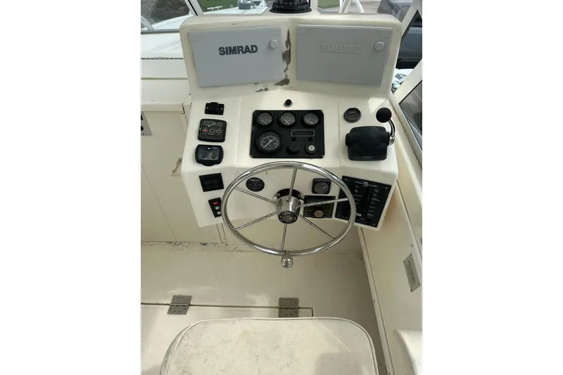 Slide: The Image of 2003 Albemarle 268 Express Fisherman boat dashboard with steering wheel and Simrad navigation system. - 22