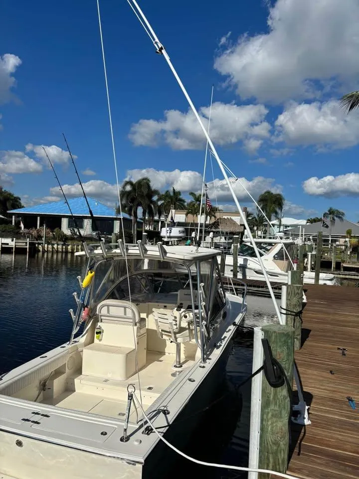 Slide: The Image of 2003 Albemarle 260 boat docked under a clear blue sky with scattered clouds. - 5