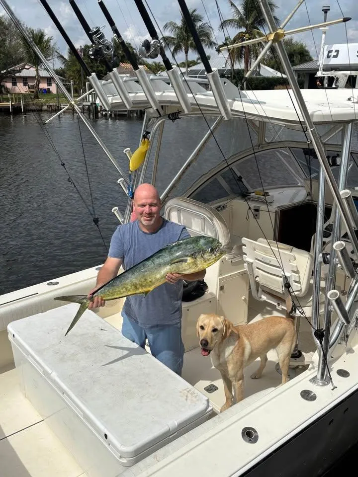 Slide: The Image of Man holding fish on 2003 Albemarle 260 boat with dog onboard. - 7