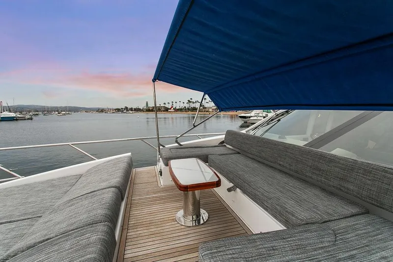 Slide: The Image of 2020 Azimut 66 yacht deck with seating, table, and canopy at sunset. - 13