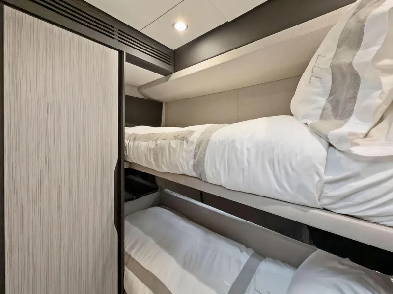 Slide: The Image of Bunk beds in the 2020 Azimut 66 yacht cabin, featuring modern design and cozy bedding. - 34