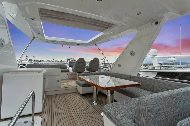 Slide: The Image of Luxurious 2020 Azimut 66 yacht deck with seating, table, and sunset view. - 6