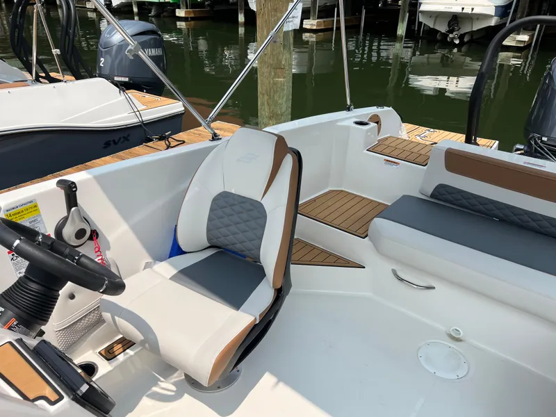 Slide: The Image of 2025 Starcraft SVX 211 OB boat interior with modern seating and steering wheel. - 11