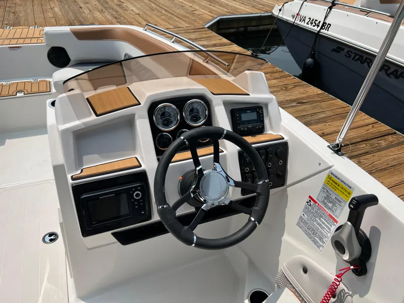 Slide: The Image of 2025 Starcraft SVX 211 OB boat dashboard with steering wheel and control panel. - 7