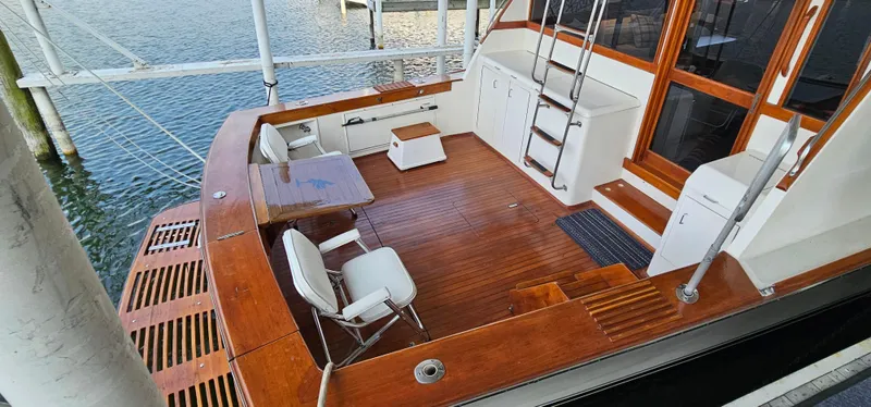 Slide: The Image of 1987 Ocean Yachts 48 Super Sport docked, featuring wooden deck and "Sea Saw" name. - 11