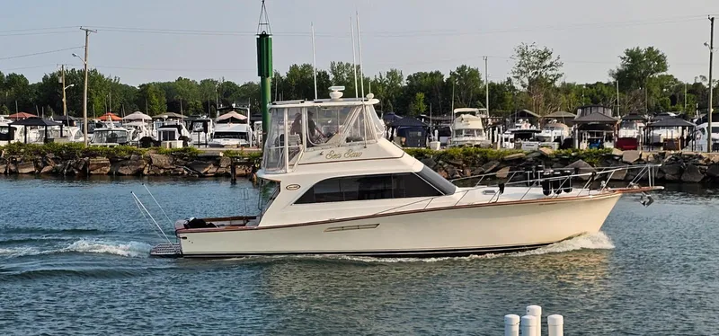 Slide: The Image of 1987 Ocean Yachts 48 Super Sport on calm water, surrounded by lush trees. - 3