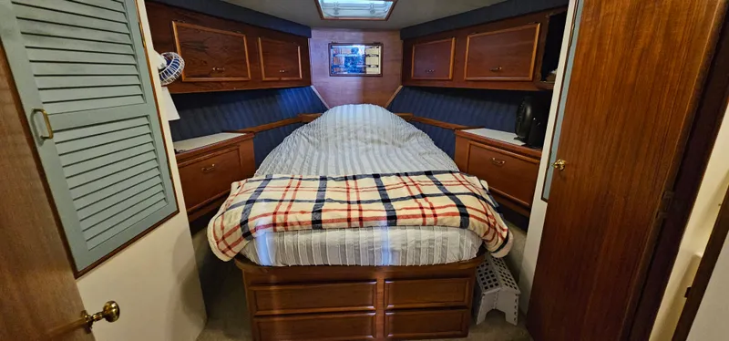 Slide: The Image of 1987 Ocean Yachts 48 Super Sport cabin with cozy bed and wooden cabinetry. - 33