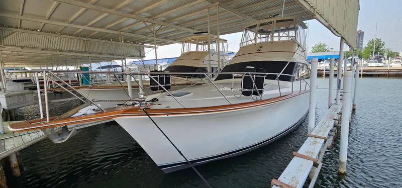 Slide: The Image of 1987 Ocean Yachts 48 Super Sport docked in a marina under a covered shelter. - 9