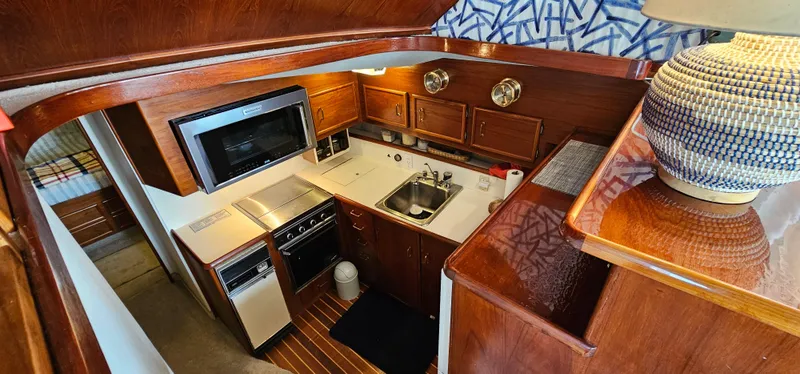 Slide: The Image of 1987 Ocean Yachts 48 Super Sport kitchen with wooden cabinets and modern appliances. - 27