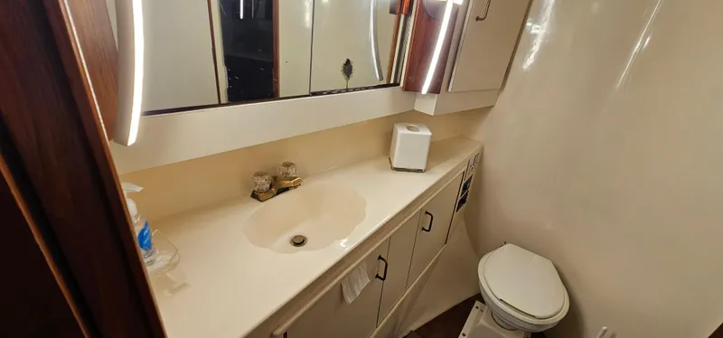 Slide: The Image of Bathroom interior of 1987 Ocean Yachts 48 Super Sport with illuminated mirror and wooden accents. - 39