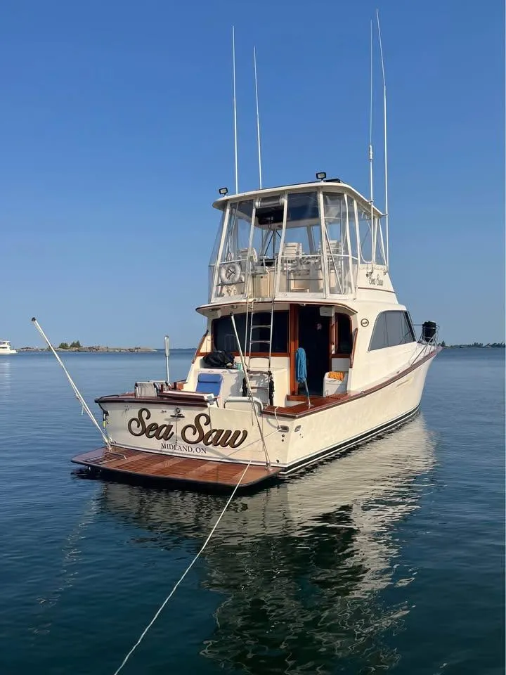 Slide: The Image of 1987 Ocean Yachts 48 Super Sport on calm water, surrounded by trees. - 6