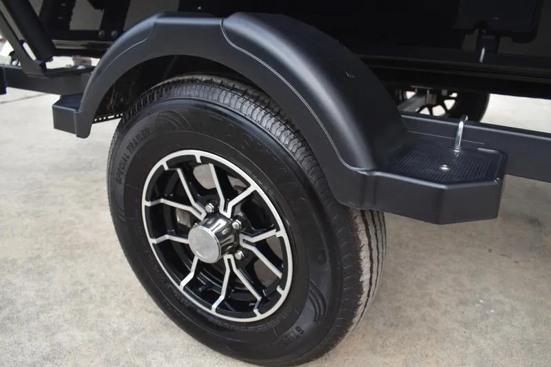 Slide: The Image of 2025 Lowe Skorpion 17 fishing boat on trailer, sleek black design, parked outdoors. - 11