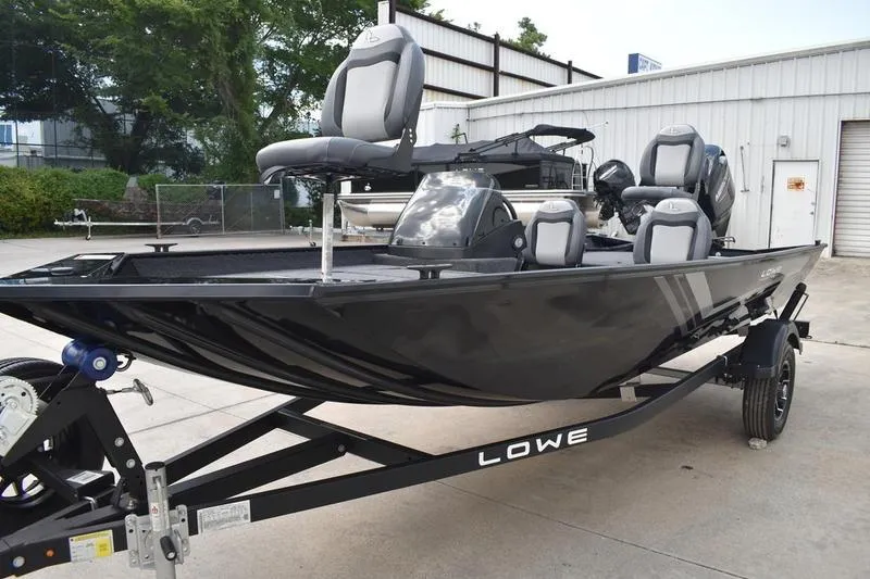 Slide: The Image of 2025 Lowe Skorpion 17 boat deck with storage compartments, gray carpeted surface. - 12