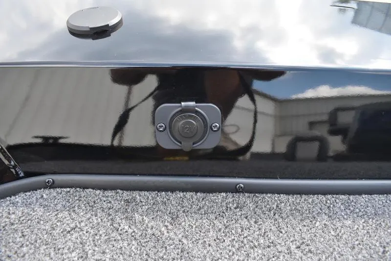 Slide: The Image of 2025 Lowe Skorpion 17 boat detail with a power outlet on a carpeted surface. - 17