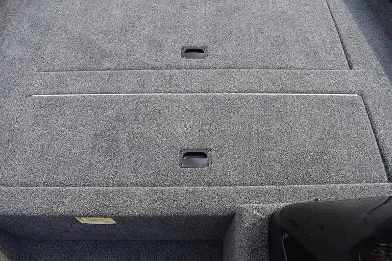 Slide: The Image of 2025 Lowe Skorpion 17 boat deck with carpeted storage compartments. - 18