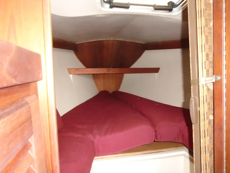 Slide: The Image of Interior of a 1988 Catalina 27 yacht with red bedding. - 9