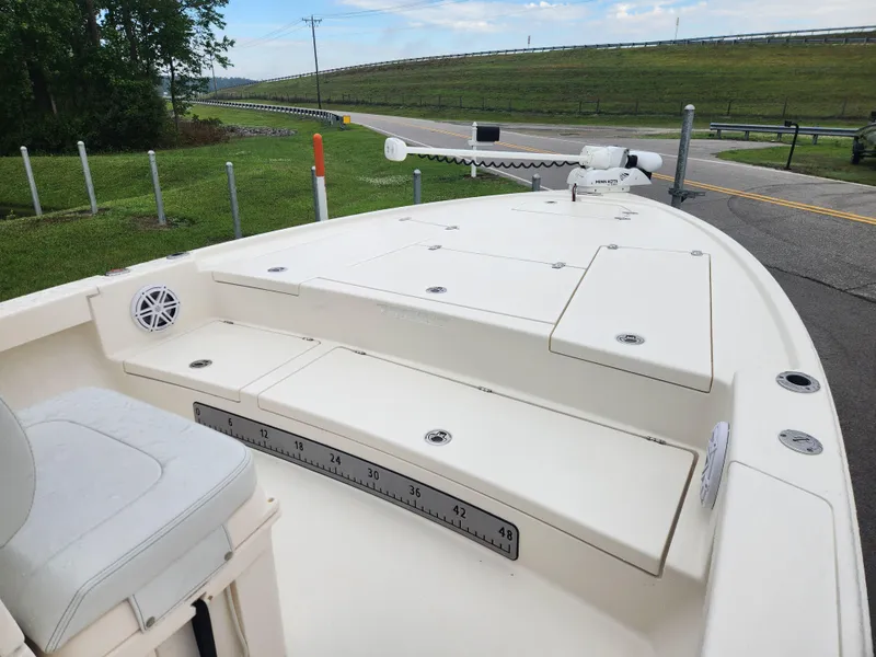 Slide: The Image of 2024 Pathfinder 2500 Hybrid boat deck with seating and storage, parked near a road. - 10