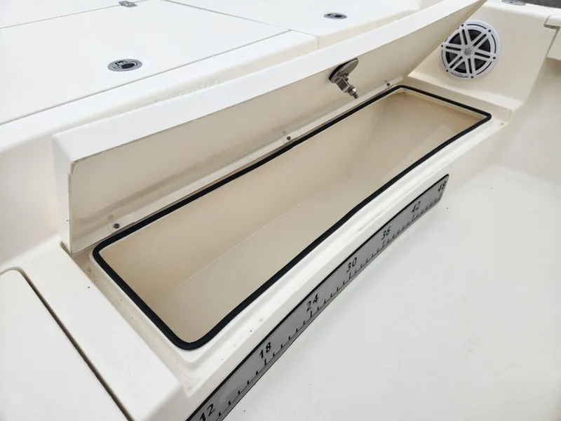 Slide: The Image of 2024 Pathfinder 2500 Hybrid boat storage compartment with open lid and built-in ruler. - 11