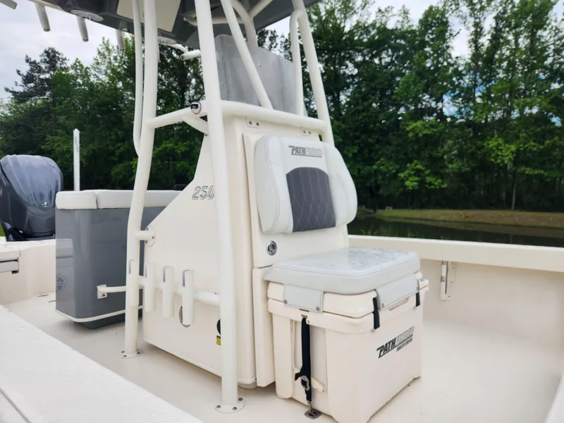 Slide: The Image of 2024 Pathfinder 2500 Hybrid boat interior with seating and storage, surrounded by lush greenery. - 13