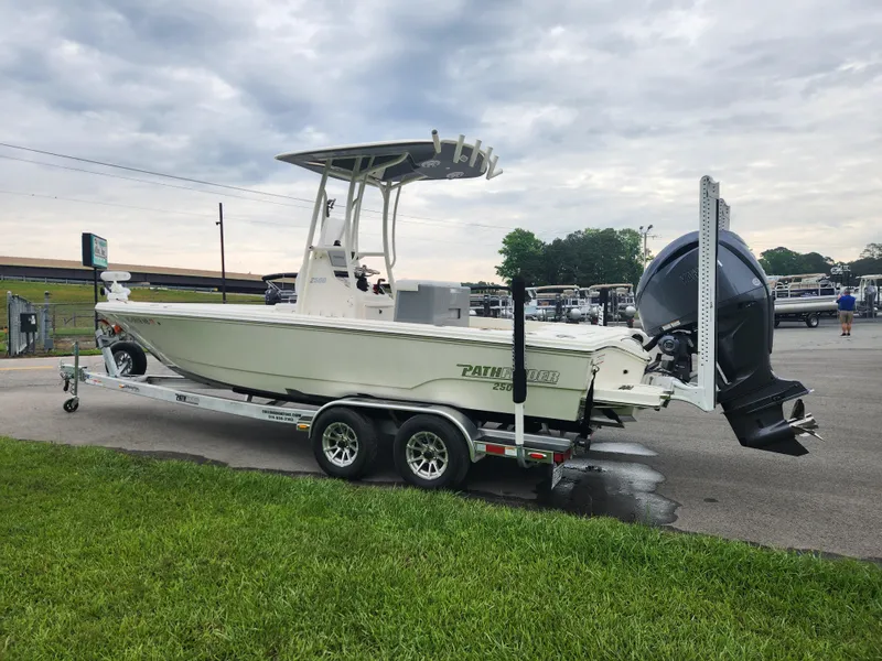 Slide: The Image of 2024 Pathfinder 2500 Hybrid boat on trailer, parked outdoors under cloudy sky. - 6