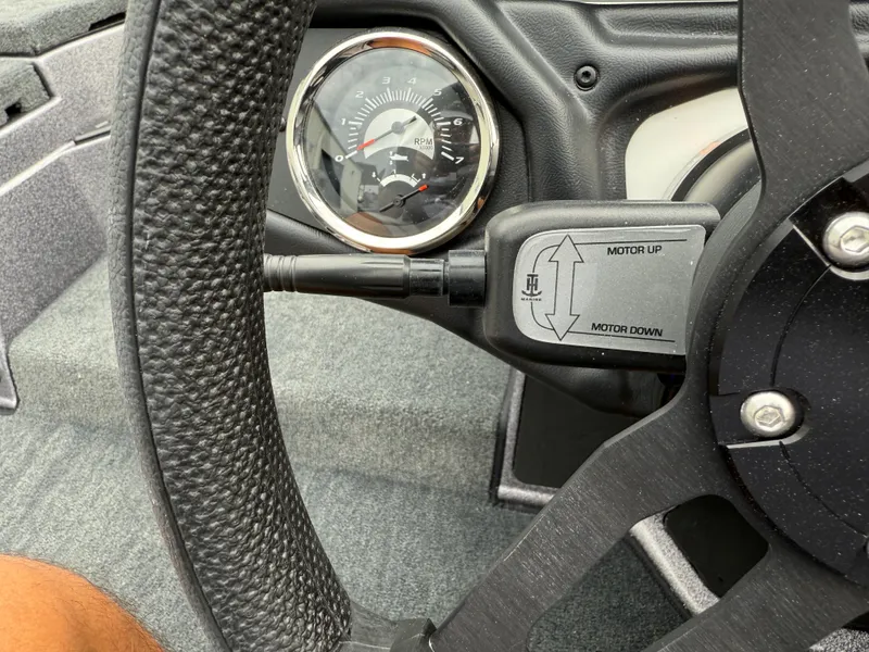 Slide: The Image of Steering wheel and controls of 2025 Skeeter ZXR 21 SE boat, featuring motor adjustment. - 12