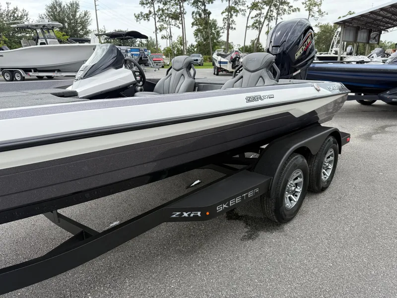 Slide: The Image of 2025 Skeeter ZXR 21 SE boat on trailer, sleek design, dual seats, outboard motor. - 4