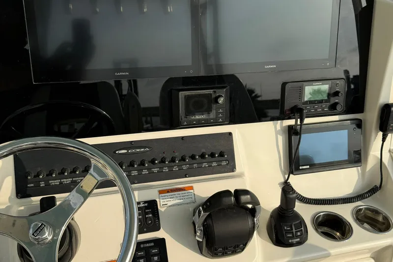 Slide: The Image of 2020 Cobia 320 Center Console dashboard with steering wheel, controls, and navigation screens. - 14