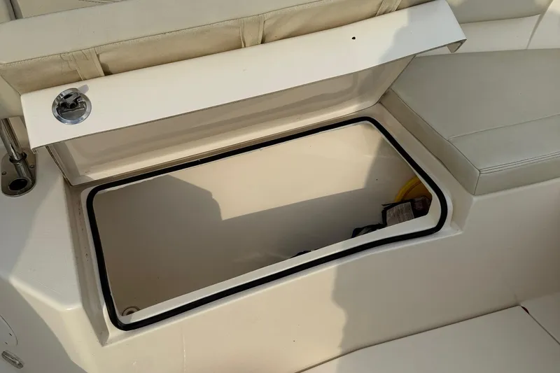 Slide: The Image of 2020 Cobia 320 Center Console storage compartment with open lid, showcasing interior space. - 19