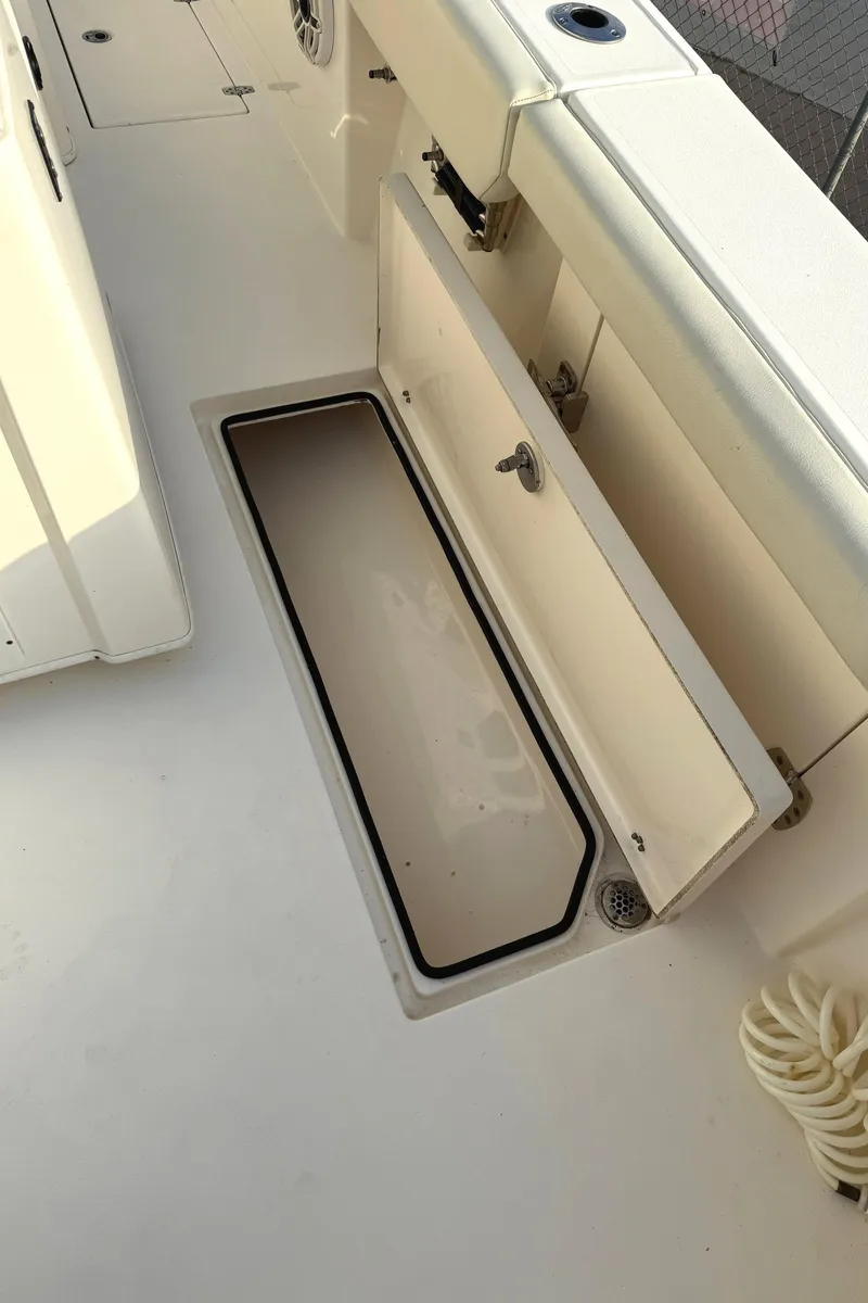 Slide: The Image of 2020 Cobia 320 Center Console boat deck with open storage compartment. - 21