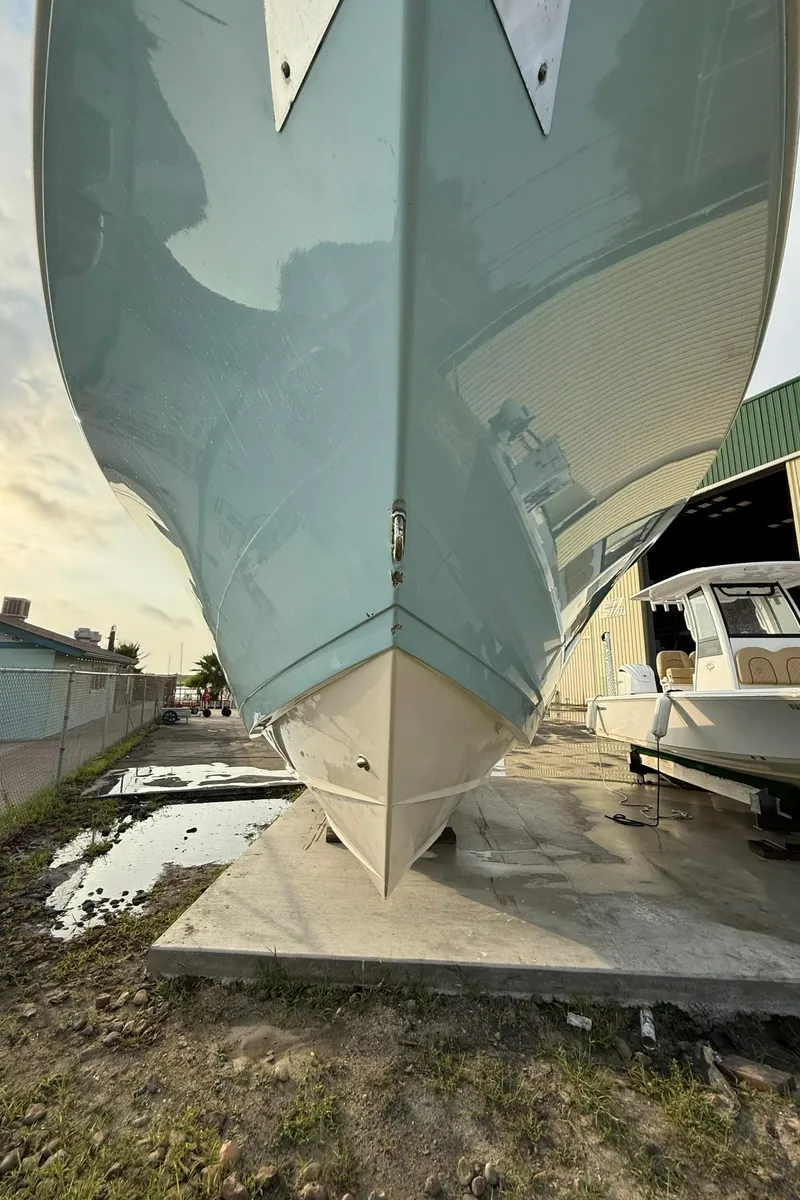 Slide: The Image of 2020 Cobia 320 Center Console boat on dry dock, viewed from the bow. - 4