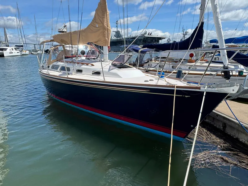 Slide: The Image of Sailboat docked in marina, Sabre 362, 2000 model, with tan sails and blue hull. - 1