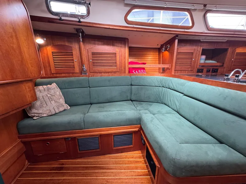 Slide: The Image of Interior of 2000 Sabre 362 yacht with green cushioned seating and wooden cabinetry. - 36
