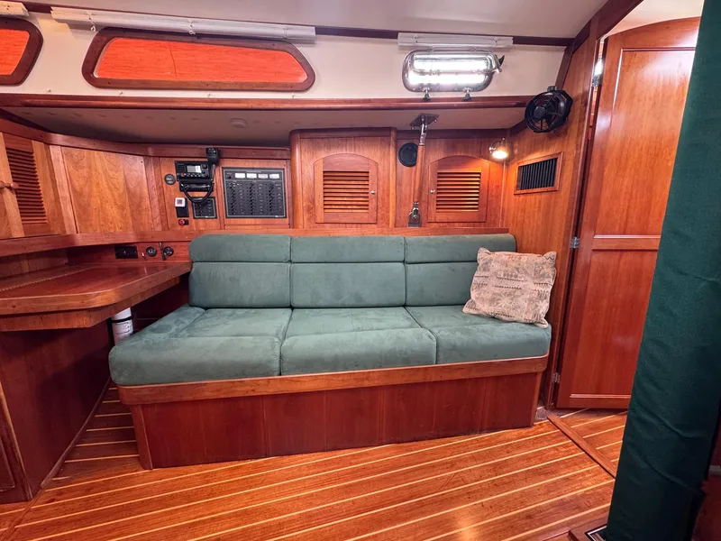 Slide: The Image of Interior of 2000 Sabre 362 sailboat with green sofa and wooden paneling. - 37