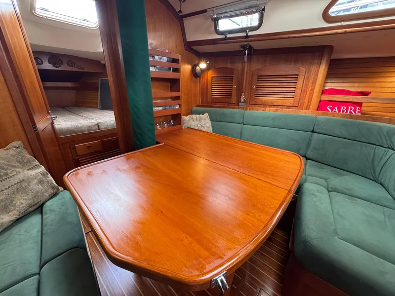 Slide: The Image of Interior of 2000 Sabre 362 sailboat with wooden table and green seating. - 39