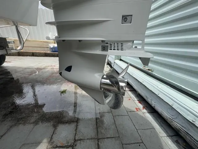 Slide: The Image of 1997 Sport-Craft 232 Sportfish boat propeller and lower unit on wet pavement. - 10