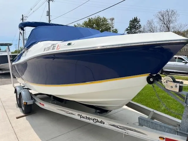 Slide: The Image of 2006 Polar Dynasty 2100 DC boat on trailer, blue and white design, parked outdoors. - 19