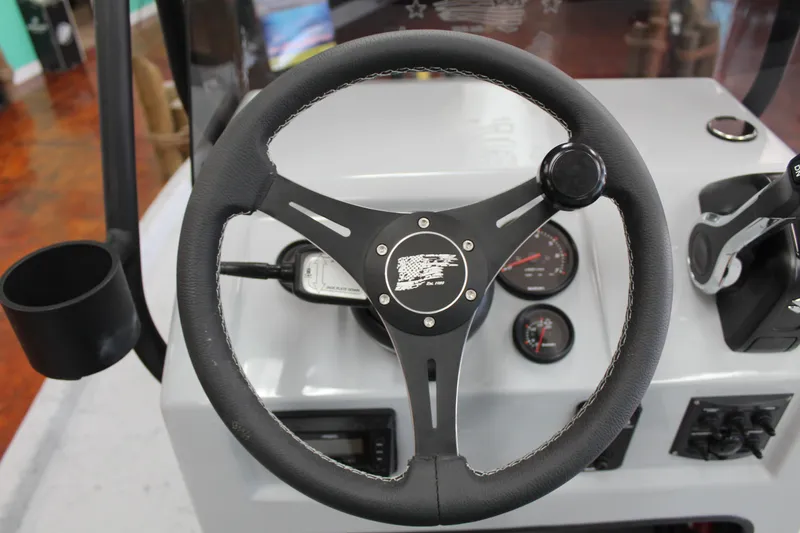 Slide: The Image of 2026 Freedom Boats Chiquita on trailer, parked outdoors under clear blue sky. - 15