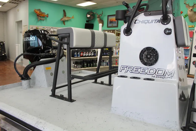 Slide: The Image of 2026 Freedom Boats Chiquita with 60 HP engine on trailer, outdoor display. - 6