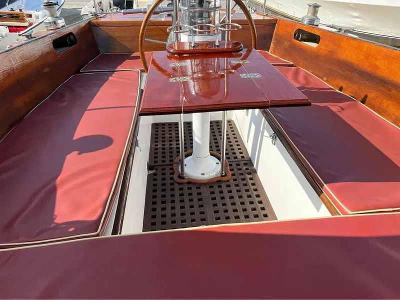 Slide: The Image of 1968 Hinckley Bermuda 40 sailboat cockpit with red cushions and wooden accents. - 11