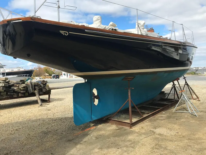 Slide: The Image of 1968 Hinckley Bermuda 40 sailboat on dry dock, showcasing its sleek hull design. - 2