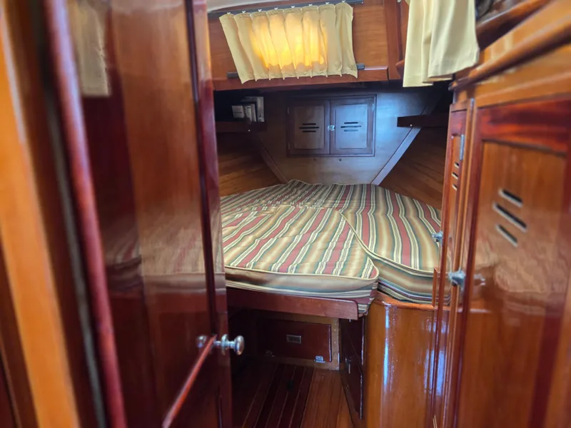 Slide: The Image of 1968 Hinckley Bermuda 40 cabin interior with striped bedding and wooden finish. - 26