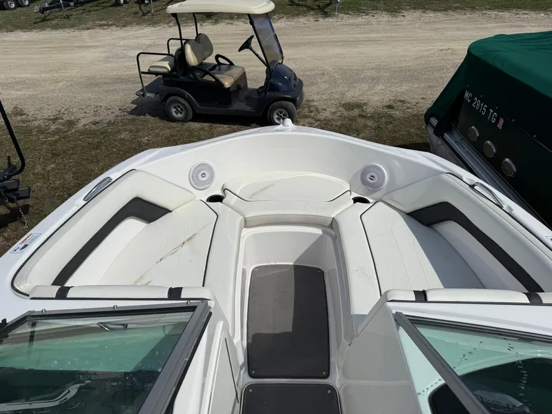 Slide: The Image of 2016 Yamaha SX190 boat interior with seating, parked near a golf cart. - 2