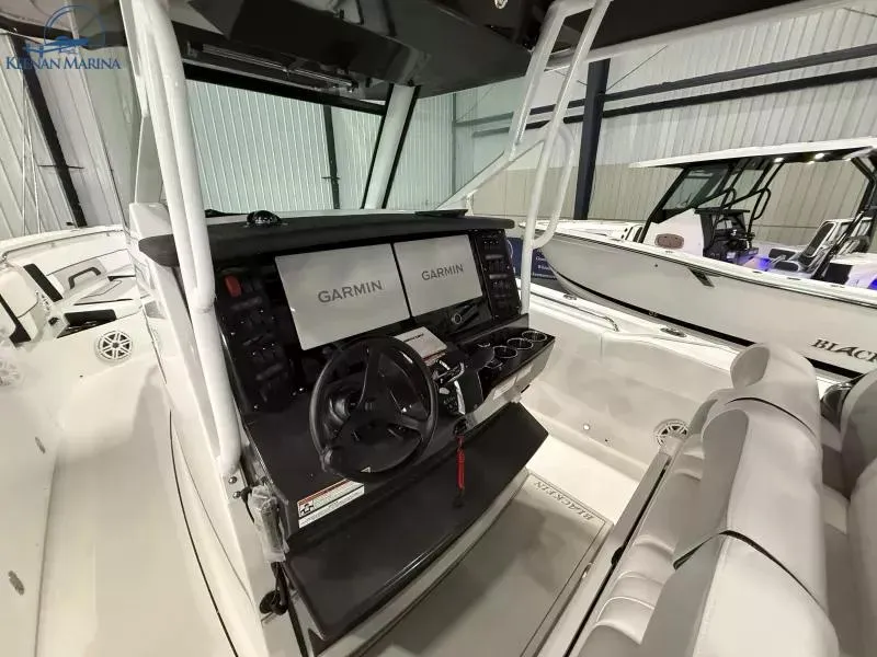 Slide: The Image of 2025 Blackfin 332 CC boat interior with Garmin navigation system and modern helm controls. - 12